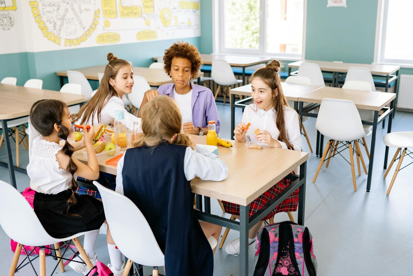 Children share a midday meal around a classroom table